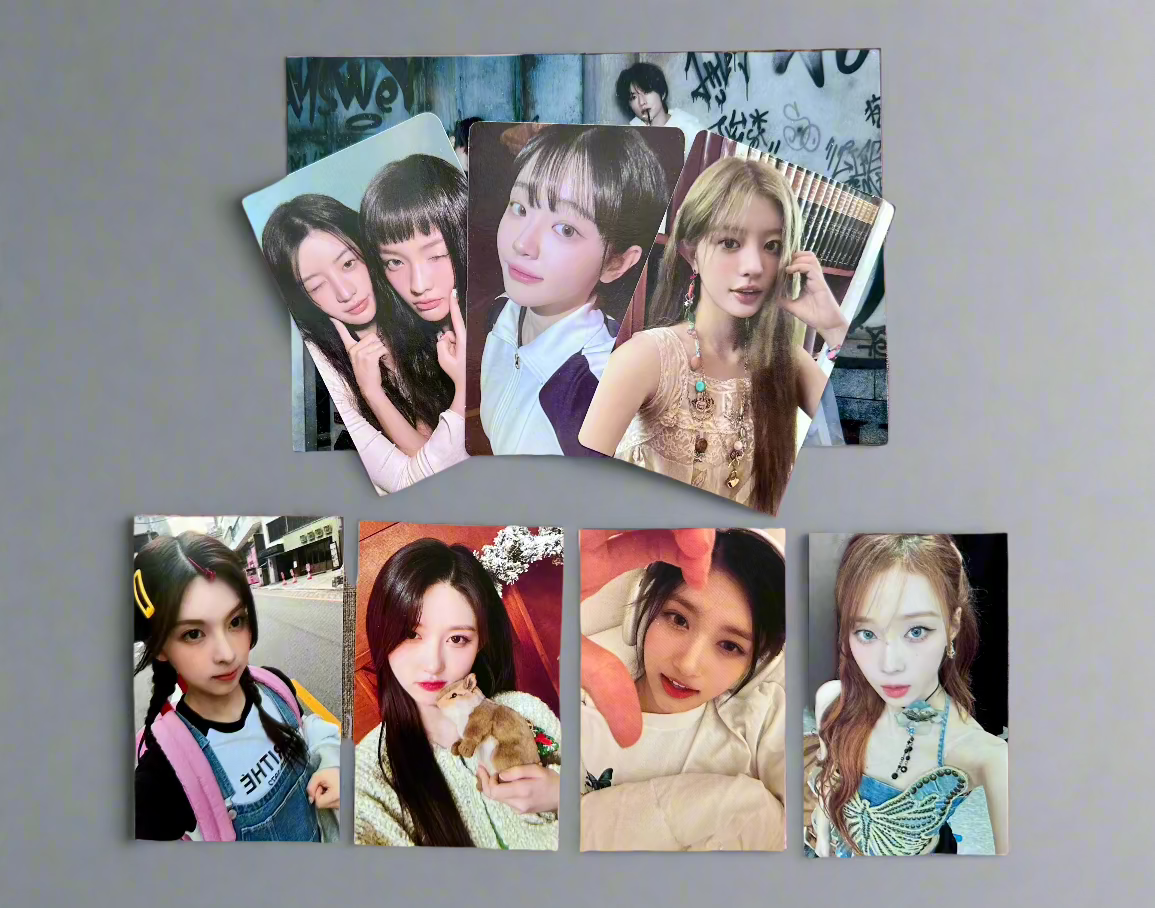 K-pop girl group photocards laid out on a table