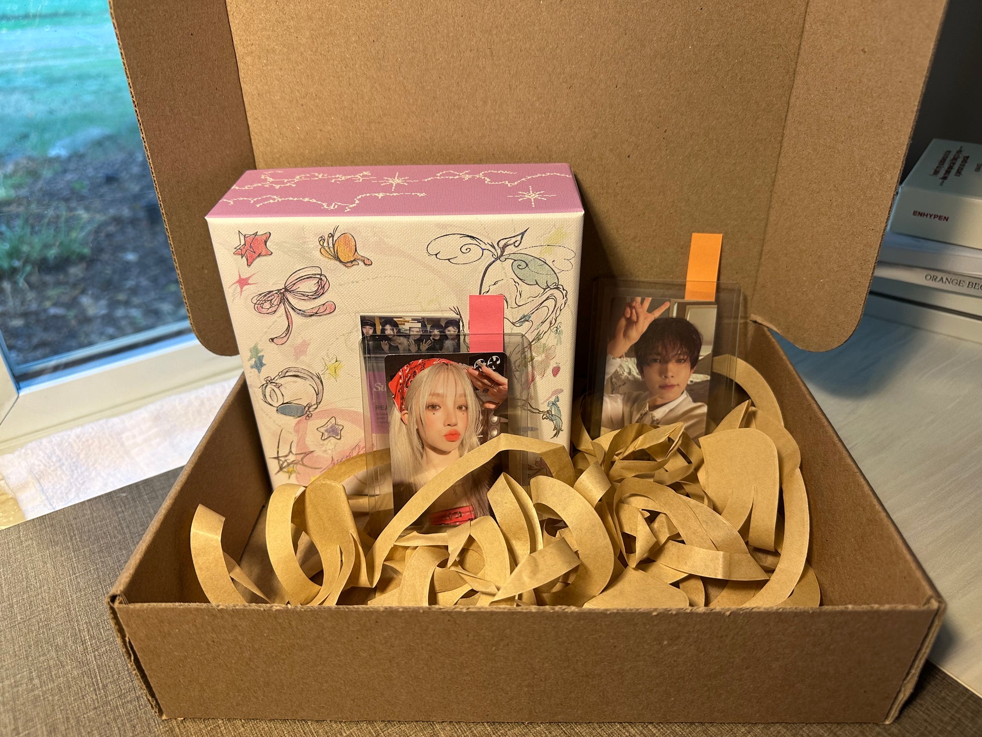 Demo subscription box with ILLIT Super Real Me album and two photocards of Yuqi and Heeseung.