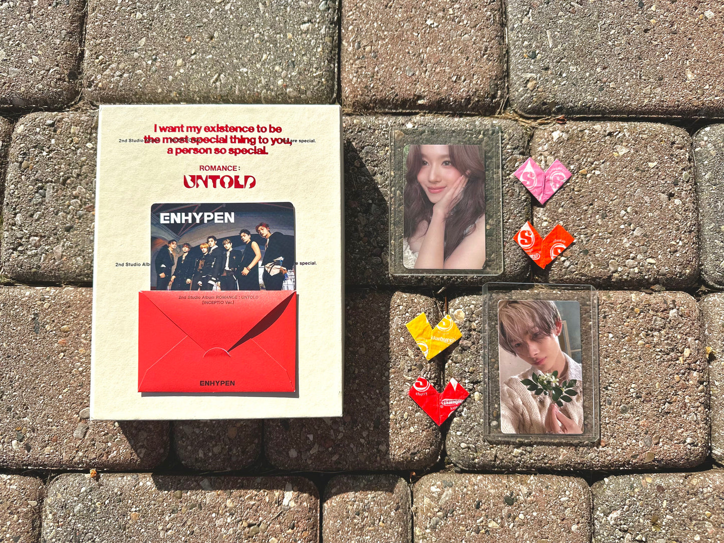 Demo box laid out with ENHYPEN's Romance Untold album, and a Sana and Ni-Ki photocard.