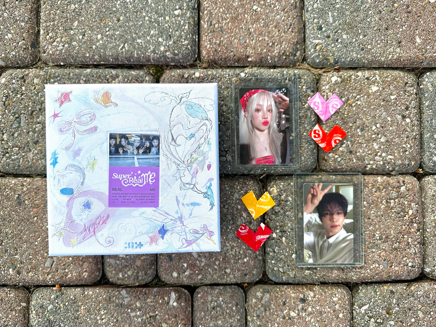 Demo box laid out with ILLIT and photocards of Yuqi and Heeseung