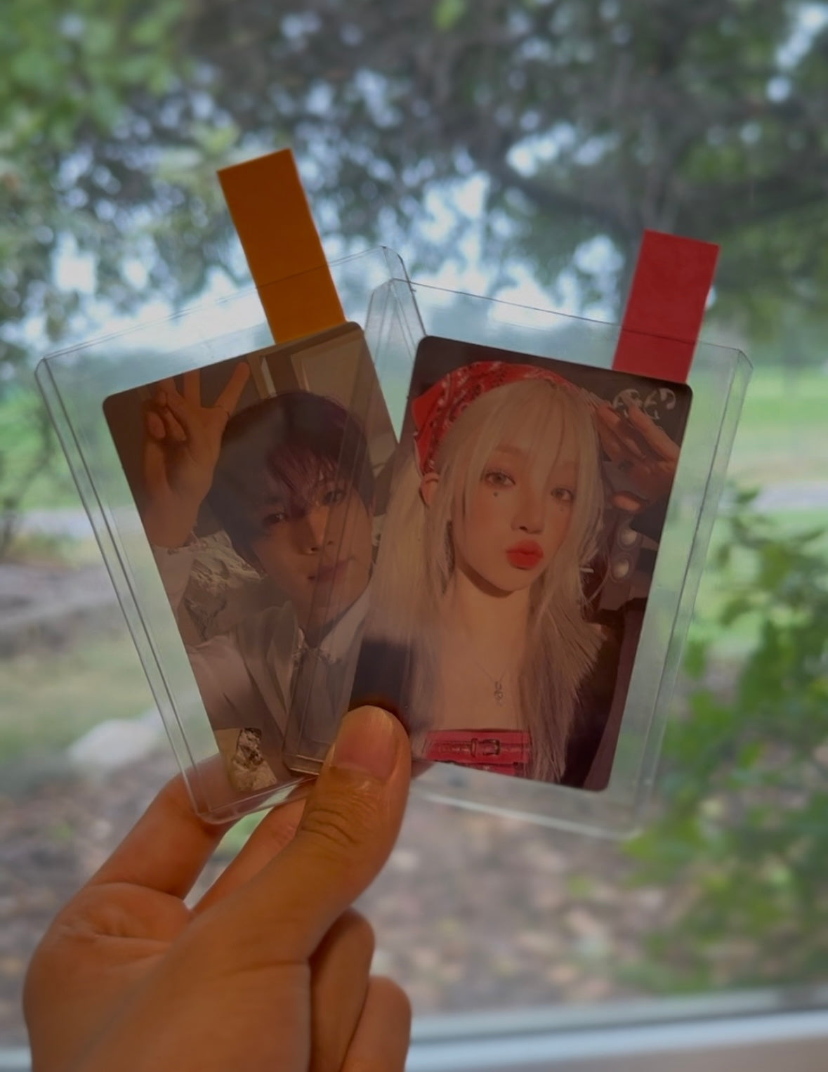 Two toploaded and packaged photocards of Yuqi and Heeseung.